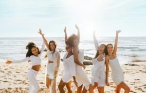 Celebración de despedida de soltera. Grupo de mujeres bailando en la playa, divirtiéndose y disfrutando de la despedida de soltera.