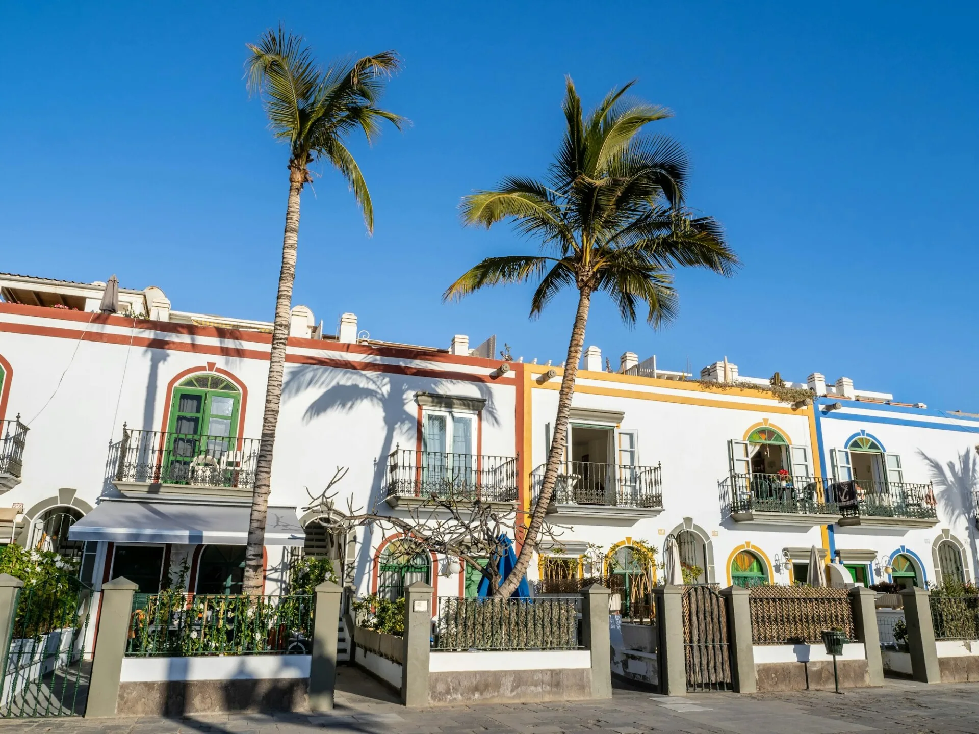 Colourful whitewashed buildings palms promenade Puerto de Mogán Gran Canaria