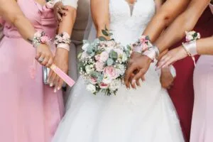 Panna młoda z bukietem i druhny w identycznych sukienkach i bransoletkach