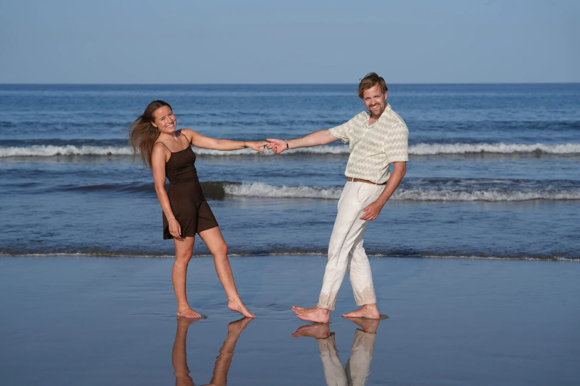 Couple on wet beach with surfboard Gran Canaria