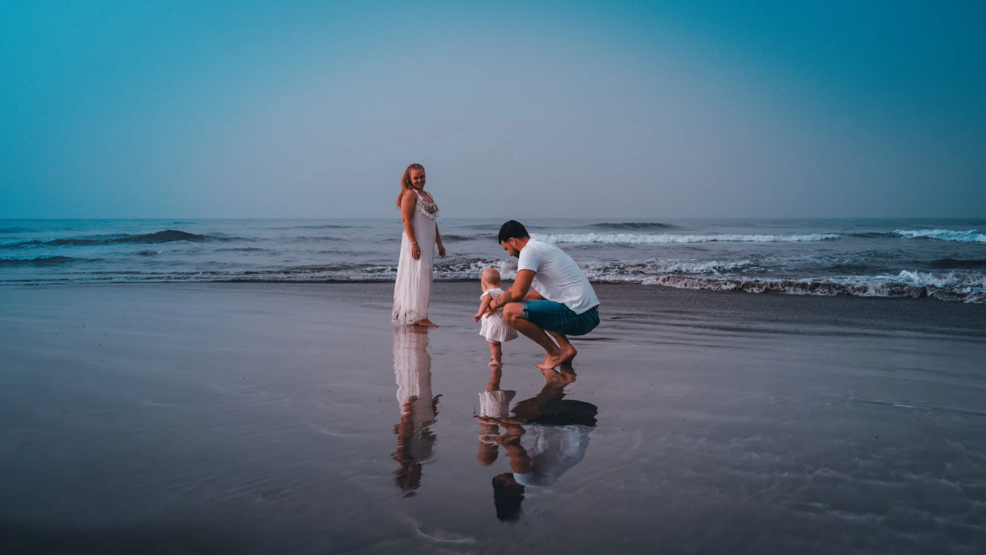 Family with young child on beach at dusk Gran Canaria