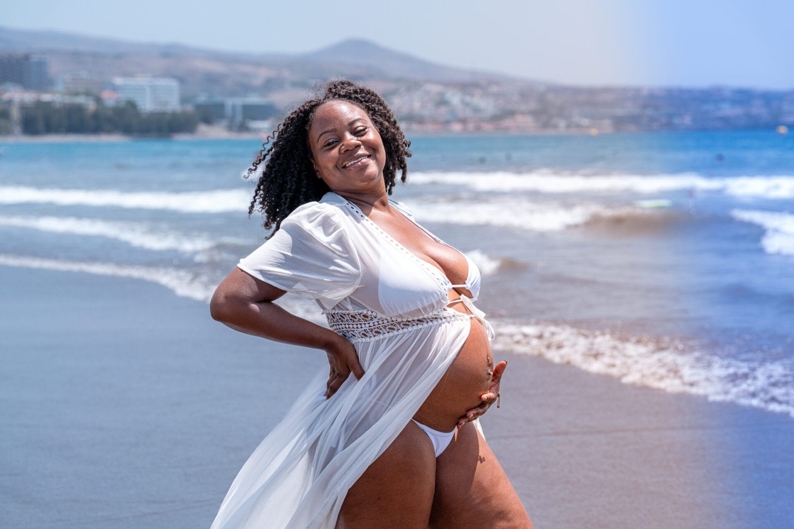 Solo maternity portrait curly hair woman on beach Gran Canaria