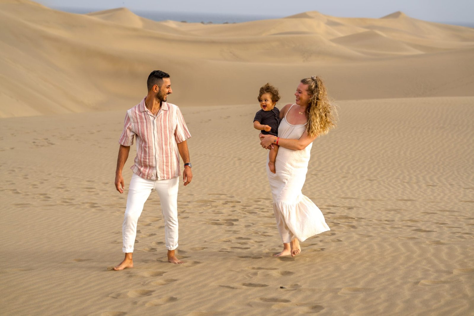 Young family with toddler on sand dunes Gran Canaria