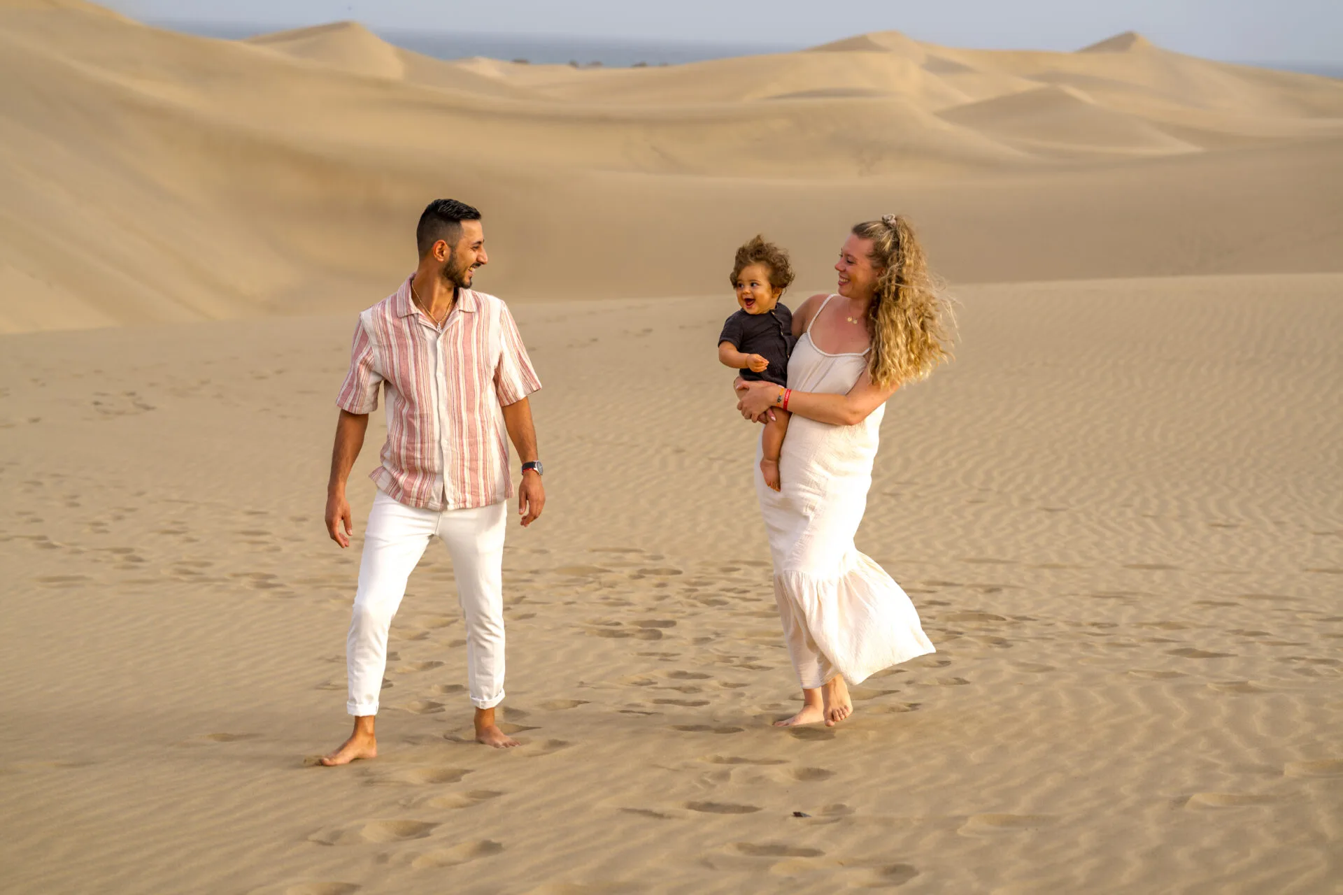 Young family with toddler on sand dunes Gran Canaria