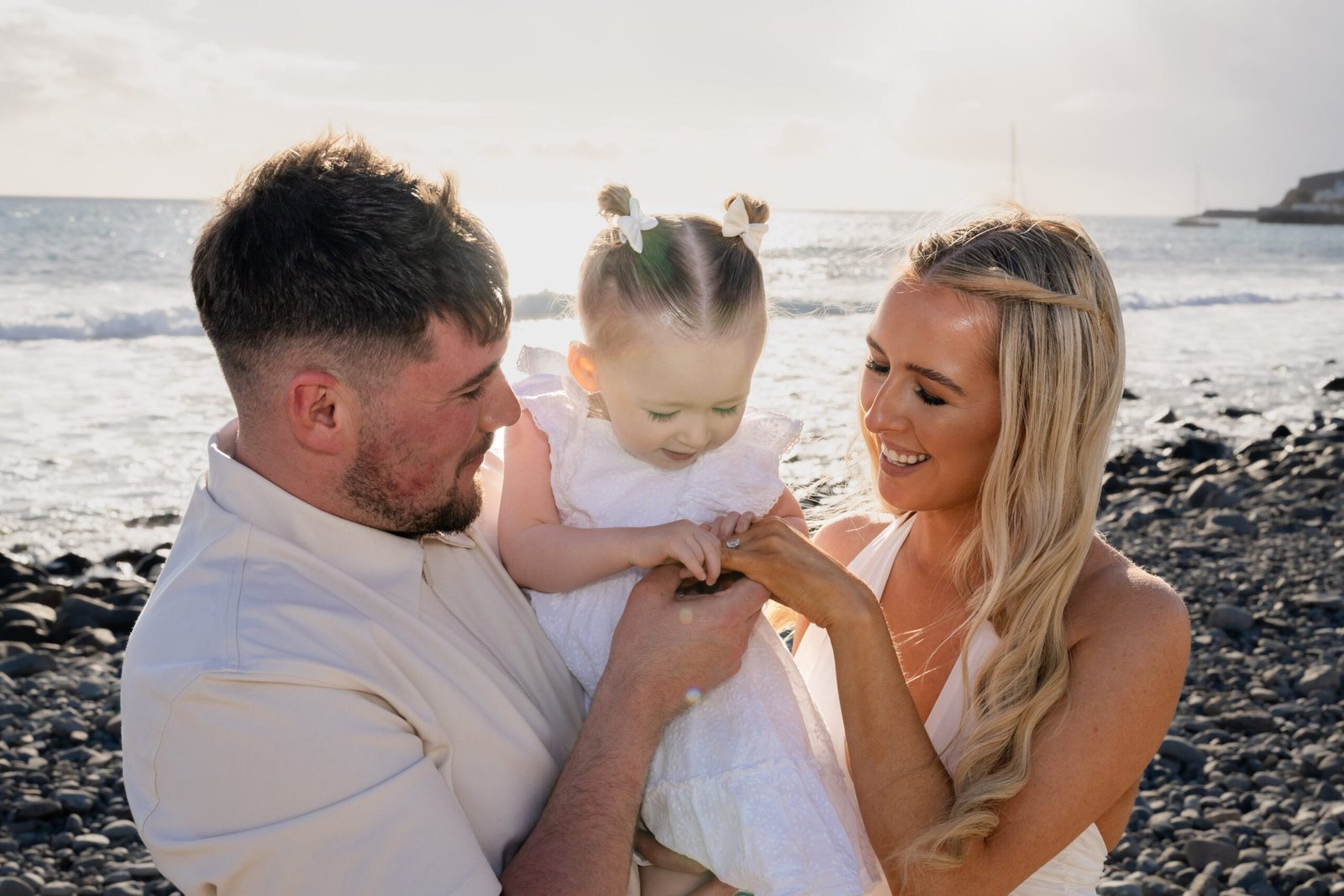 Young family with baby on pebble beach Gran Canaria