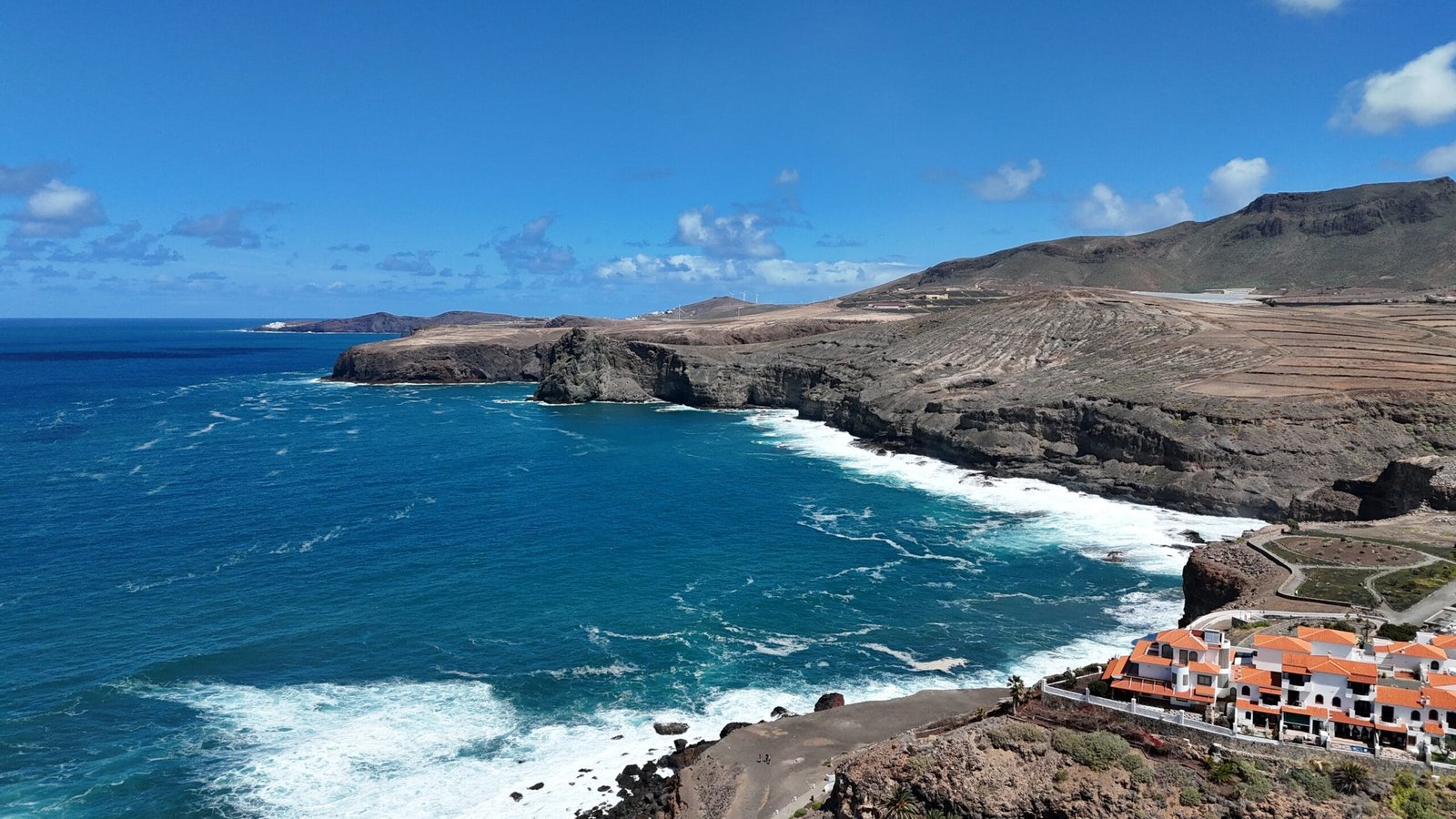 Drone aerial view Agaete coastline volcanic cliffs train mountains Gran Canaria