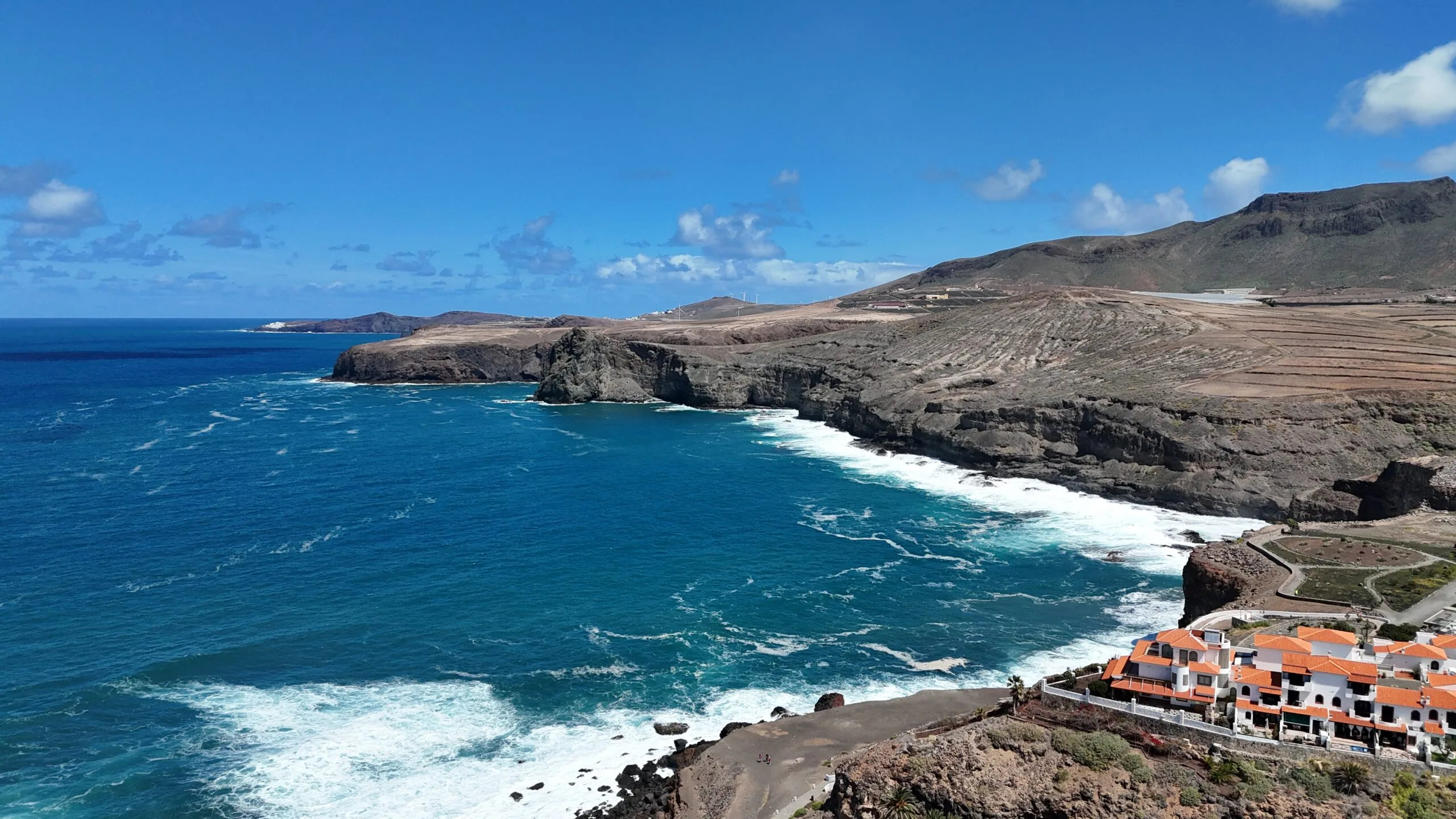 Drone aerial view Agaete coastline volcanic cliffs train mountains Gran Canaria