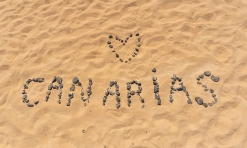 Canarische naam met zwarte stenen op het strand van de duinen van Corralejo